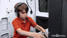 a young boy wearing headphones and a microphone is asking what that means