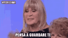 a woman with blonde hair is making a funny face and saying pensa a come ti chiamano al tuo paese