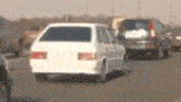 a white car is driving down a highway next to other cars