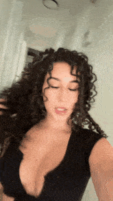 a woman with curly hair takes a selfie