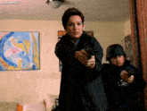 a woman is pointing a gun at a man in a helmet in a room with yazbitmeslin written on the bottom
