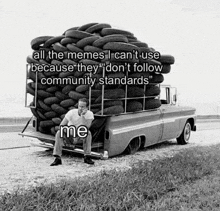 a man is sitting in the back of a truck with tires on the back .