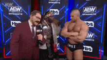 two men are standing in front of a wall that says aew wrestling