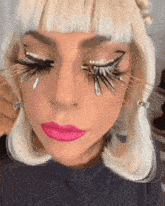 a close up of a woman 's face with feathered eyelashes and pink lips