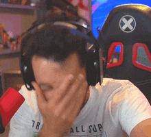 a man wearing headphones and a shirt that says all sup is covering his face