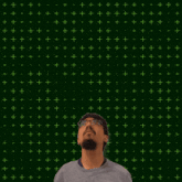 a man is looking up at a glowing number six