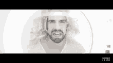 a man with a beard and long hair is wearing a white shirt and a crown .