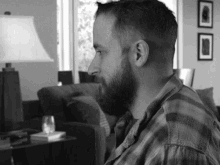 a man with a beard is sitting on a couch