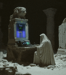 a person in a white robe is sitting in front of a computer with a screen that says " o " on it