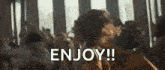 a group of people are dancing in a room with the words `` enjoy '' written on the bottom .
