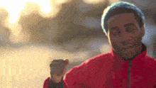 a man with blue hair is wearing a red jacket and a blue beanie