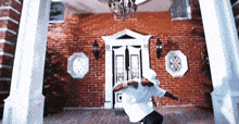 a man is standing in front of a brick building
