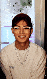 a young man wearing glasses and a white shirt that says 2m8j9