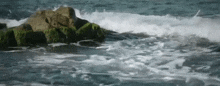 waves crashing against a rocky shoreline in the ocean