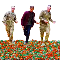 three men in military uniforms are dancing in a pile of candy
