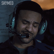 a man wearing headphones and a microphone with the word skymed on the bottom