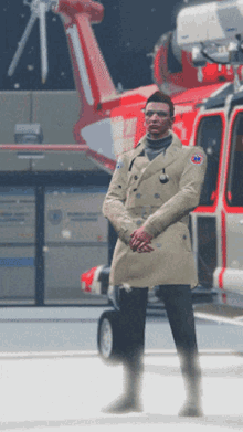 a man in a trench coat is standing in front of a red helicopter