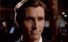 a close up of a man in a suit smiling .