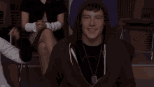 a young man wearing a hooded sweatshirt is smiling