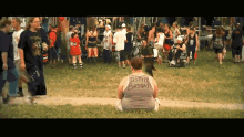 a woman wearing a shirt that says " it 's my birthday " sits on the grass