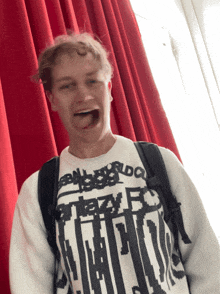 a man wearing a white sweater with a black and white graphic that says ' a ' on it
