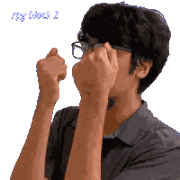 a man wearing glasses is covering his face with his hands and the words big duck 2 are visible in the background