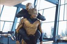 a man in a superhero costume is carrying a woman on his shoulders