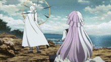 a man and a woman are standing next to each other on a rocky hill .