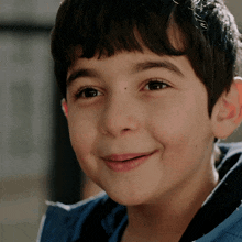 a close up of a young boy 's face with a smile on his face