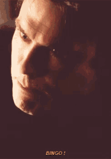a close up of a man 's face with the word bingo written below it
