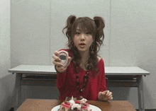 a woman is sitting at a table with a plate of food and a cell phone in her hand