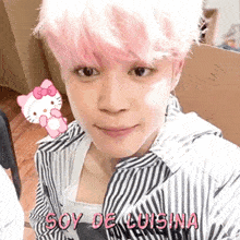 a man with pink hair is taking a selfie with a hello kitty sticker .