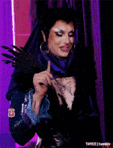 a drag queen has a tattoo of a butterfly on her chest and has the number 2 on her arm