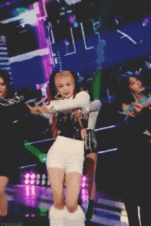 a woman with red hair is dancing on a stage with a microphone in her hand .
