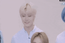 a group of people are standing next to each other in a room and one of them is smiling .