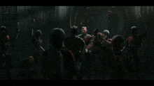 a group of robotic soldiers are standing in a dark room holding weapons .