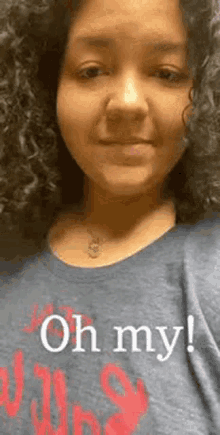 a woman with curly hair wearing a t-shirt that says oh my !