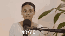 a woman speaking into a microphone with a plant in the background and the word ethiopia on the bottom