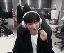 a man wearing headphones is sitting in a chair with a microphone