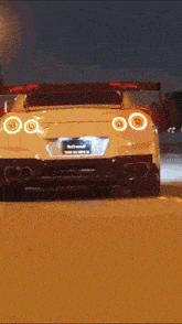 a white sports car is driving down the road at night .