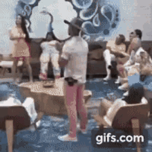 a group of people are sitting around a table in a living room .