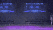 a group of women are dancing on a stage with a large screen behind them that says ' cosme ' on it