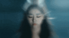 a blurry picture of a woman with her eyes closed behind a glass