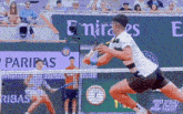 a tennis match is being played in front of a emirates sign