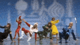 a group of people are dancing on a stage with microphones .