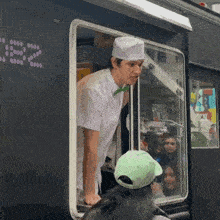 a man in a white hat is standing in front of a food truck with the number 25 on the side