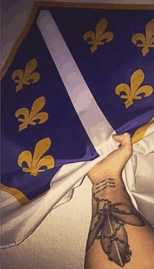 a person with a tattoo on their arm is holding a blue and white flag