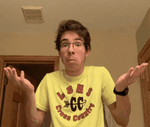 a young man wearing a yellow shirt that says ushs cross country