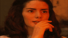 a close up of a woman 's face with a hand on her mouth