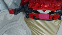 a close up of a red belt with a pink button
